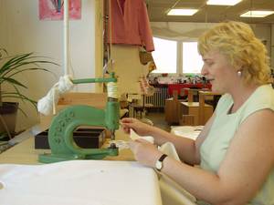 Eine Frau arbeitet an der N�hmaschine.