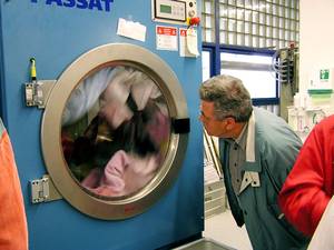 Person betrachtet eine blaue Waschmaschine