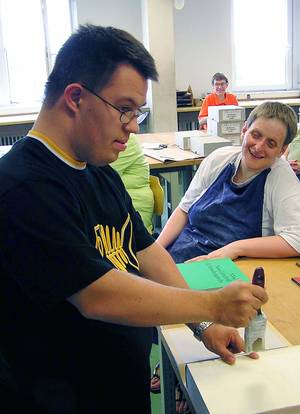 Buchbinderrei, ein Mann leimt ein Buch