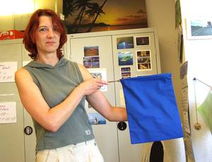 Eine Frau pr�sentiert das N�hergebnis.